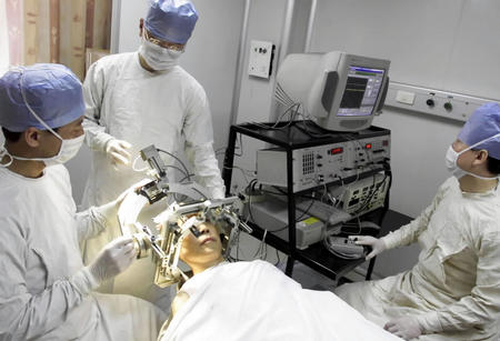 我国每年新增近10万帕金森病人: 解放军微创神经外科中心医务人员在为帕金森病患者做手术