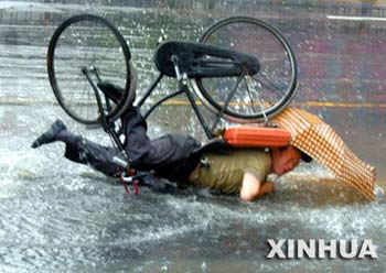 雨中骑车人摔跤照片引发网民热议记者职业伦理