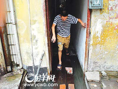污水难排浸小楼 砖头木板搭路扶墙拄杖通行(图)