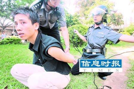 防暴警员正用警绳把抓获的男子绑住.