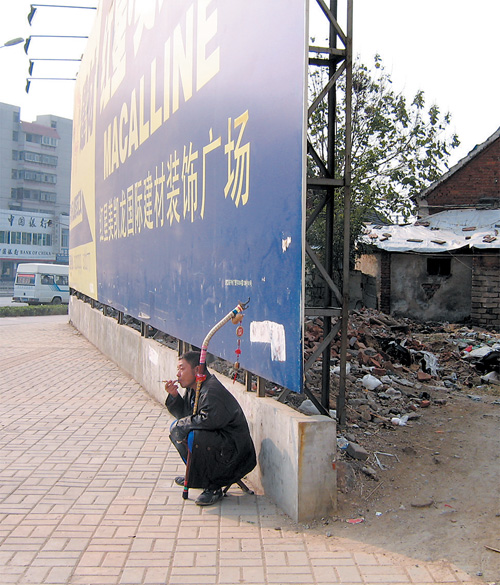 沿路房屋因道路改造拆除后,没拉围墙,只有一个沿路大广告牌作为遮挡