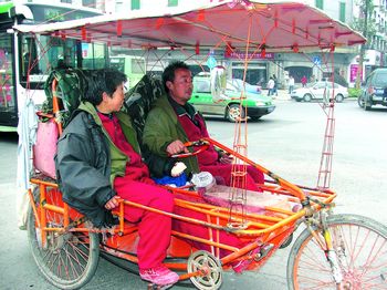 李祥林夫妇就是骑着这辆自制的三轮"房车"游遍了全国26个省(市,区).