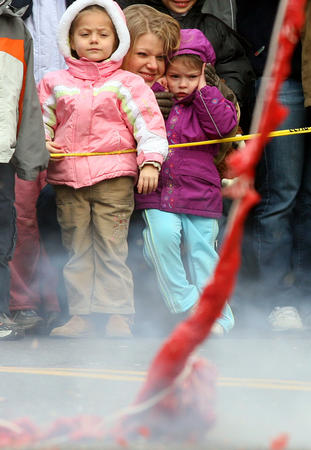 图文:一位母亲陪孩子在中国城观看放鞭炮