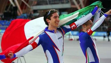 图文：冬奥速滑队际追逐 意大利队员披国旗致意