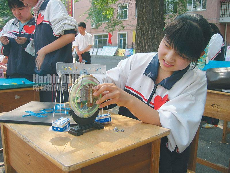 三年六班徐鑫用废旧的温度计、格尺、线绳和纸壳、钉子等制作的天平,造型特别优美(图)。二年五班姚小桐用大米和红小豆制作出了的工艺品挂件(图)。 在家务区,几名同学正在认真地洗着教室里的窗帘和桌布。学校一楼的教室,则成了孩子们展示厨艺的舞台。一盘用黄瓜丝、粉丝和胡萝卜丝做底衬,上面摆着用西红柿刻出大花的凉盘,看上去颇有专业水平(图)。记者在教室里看到,不少学生围在一起正在擀皮包饺子,虽然有的学生用手抻饺子皮,有的把饺子包成了包子,但学生们做得都很认真。