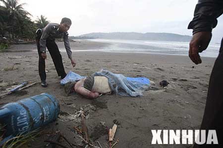图文：救援人员在沙滩上发现一具遇难者的尸体