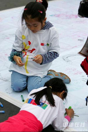 图文：北京国际马拉松赛鸣枪 小朋友为比赛绘画