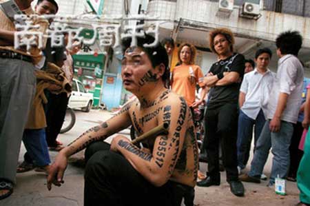 方光明/图6/2006年4月，东莞一名贴“牛皮癣”的男子身上被环卫工人印...