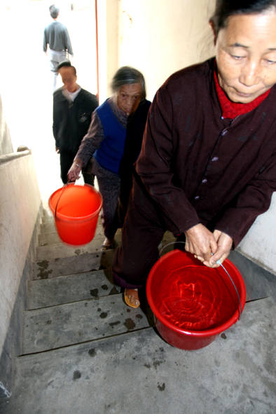 居民遭停水停电 七旬阿婆每天提水要爬百层楼