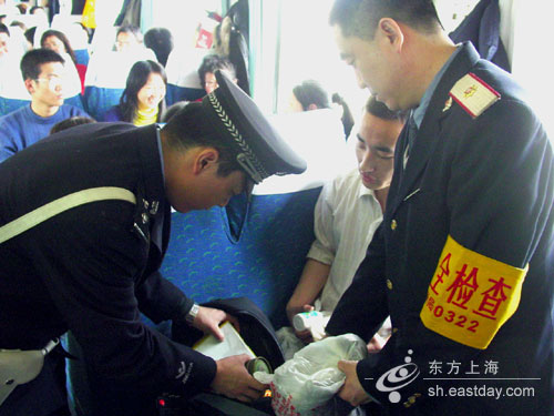 图片说明:乘警和列车安全员在检查危险品