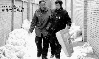 孙连忠正搀扶着父亲在风雪中前行(3月9日摄.