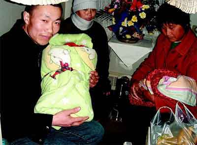 4月5日，柳超、林绘夫妇抱着双胞胎女儿，高高兴兴地坐上了回徐州老家的火车。李心页 摄