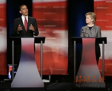 纽约州参议员希拉里正在听伊利诺斯州参议员奥巴马回答问题。美国民主党候选人4月26日晚上在南卡罗莱纳州立大学举行竞选总统的第一轮辩论。