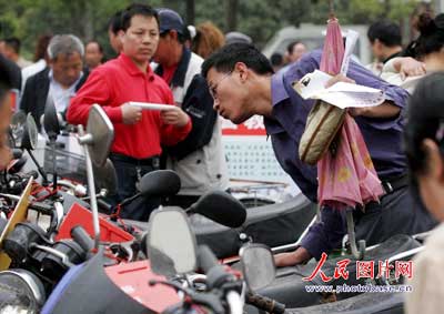 一名市民在展示的被盗抢摩托车中找寻自己的爱车。