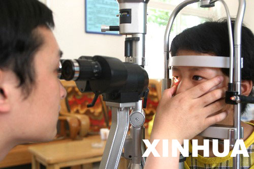 5月27日,医务工作者正在为一名残疾儿童检查眼睛.