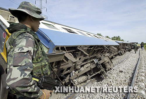  6月4日，在泰国南部的北大年府，政府军士兵在出轨的列车旁警戒。