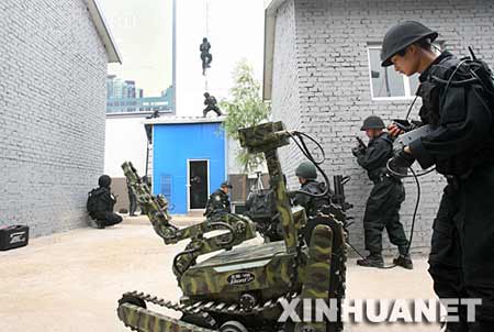 一名突击队员（右一）在操控机器人探测危险品。 新华社记者 庞兴雷 摄