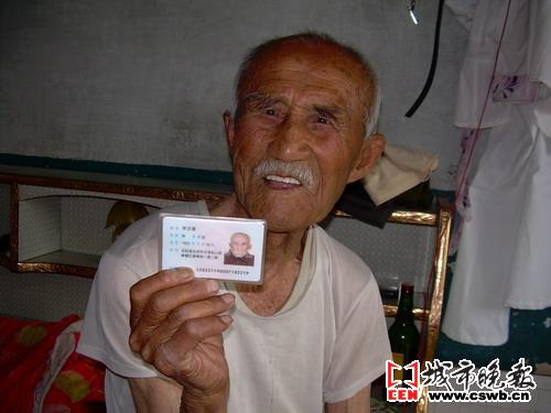 老人展示自己的身份证单丹/摄