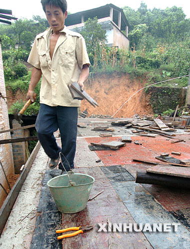 7月29日，湖北恩施市六角亭书院村村民刘远军在重建倒塌的房屋。