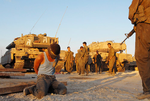 8月14日，加沙，以色列士兵看押一名在军事行动中被拘捕的巴勒斯坦人。