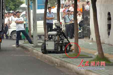 排爆机器人在处理疑似爆炸物（圆圈标注处）。 