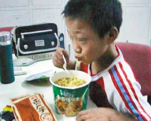 被解救的12岁少年李健(化名)正在110民警办公室吃泡面