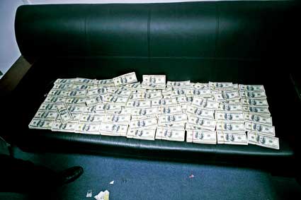 警方在韩某家中找出的现金摆满了沙发摄/通讯员杨枢