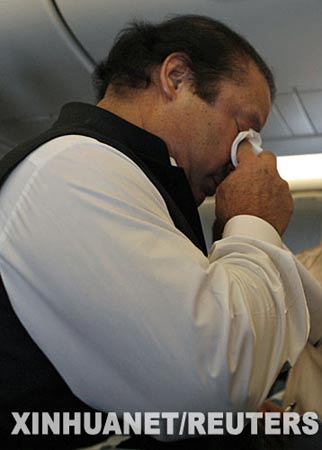9月10日，在巴基斯坦伊斯兰堡国际机场，巴基斯坦流亡前总理纳瓦兹·谢里夫在下飞机前擦拭眼睛。新华社/路透