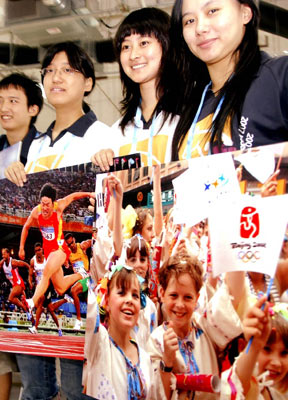 志愿者在北京国家会议中心展示奥运主题宣传画。