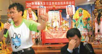 “新闻局长”谢志伟（左）边跳边唱妈祖支持入联的rap；嘉义县长陈明文（右）则在一旁沉思。（图片来源：台湾《联合报》）