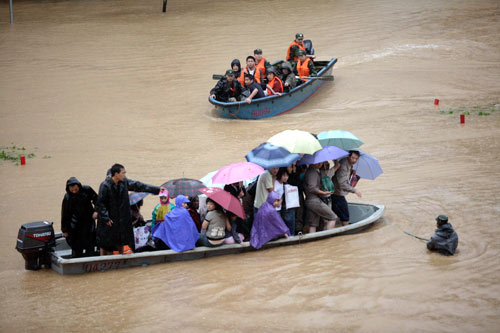 10月8日，杭州，武警战士使用冲锋舟帮助受困居民撤离被洪水淹没的街道。