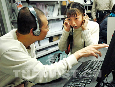 盲人学员徐健（右）在老师指导下编辑广播节目