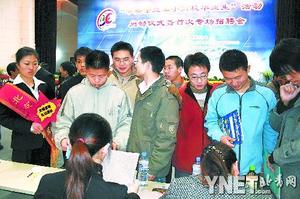 北京城市学院的志愿者（左一）在招聘会现场引导求职者“文明应聘” 摄影/宋旸