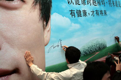 图文:刘翔鲍威尔参观安利产品 在海报上签名