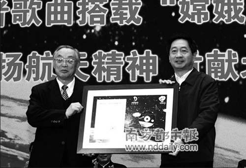 栾恩杰向梁伟交接录有“嫦娥一号”卫星回传的奥运志愿者歌曲《微笑北京》的光盘