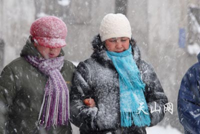 26日中午:40分左右,记者在市后泉街拍到的人们在雪中行走的