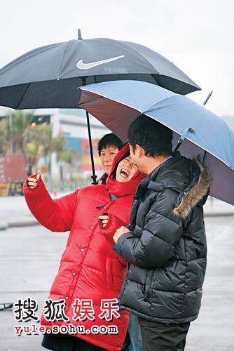 虽然天寒地冻站在街上等雨停好惨，然而二人却仍谈笑自如。