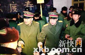 广州军区司令员章沁生（中）、政委张阳（左一）与参加抗灾的部队官兵一起度过除夕之夜。 