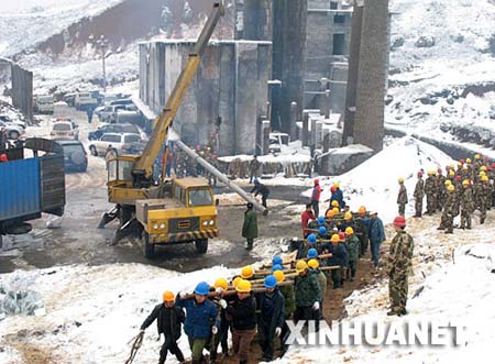 2月6日，电力工人在冰天雪地中将重达1吨的大型水泥电线杆运上山。