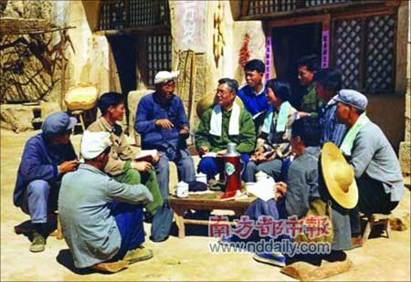 1974年5月许林在陕西省南泥湾摆布导演拍摄的《南泥湾五七干校》。“摆布中,我尽量注意细节:老农的羊角巾、人物背后的草帽、手中的笔记本、脖子上的毛巾、桌子上的水杯、水壶以及人物坐姿的高低错落等等。这哪里是拍新闻照片,简直就是在演戏!”