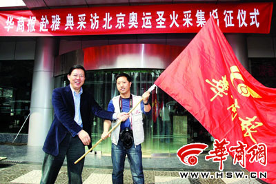 本报记者邓小卫从执行社长周怀忠手中接过报社的旗帜 本报记者 赵彬 摄