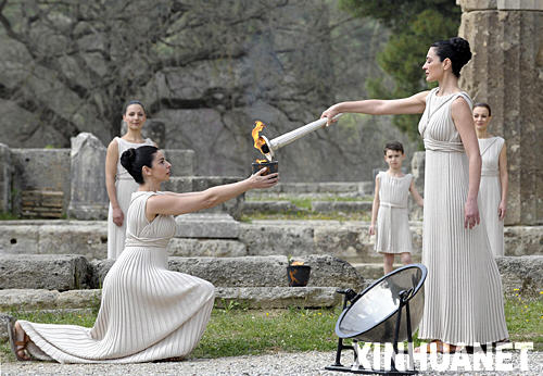 3月24日，北京奥运会圣火取火仪式在希腊奥林匹亚举行。图为扮演最高女祭司的玛利亚·娜芙普利都（前右）点燃火种罐。 新华社记者戚恒摄