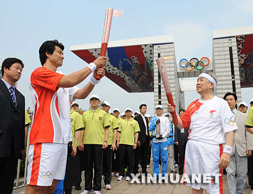 4月27日,奥运火炬手,韩国奥委会主席金正吉(前右)与文大成在传递