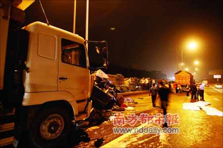 昨天下午6点35分,深圳南坪快速路长岭坡大桥路段发生特大交通事故。图为消防员正在切割被挤大货车。