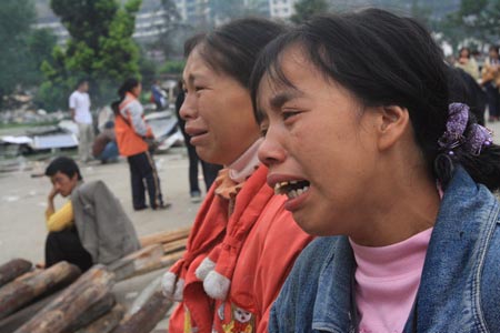 两位孩子的妈妈，在小学的操场上，等待废墟中孩子的身影出现