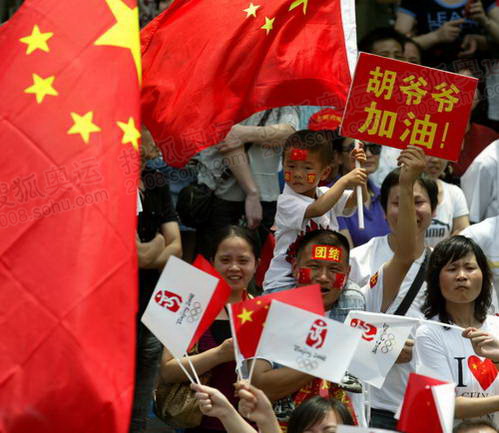 杭州火炬传递，圣火传递现场，一对父子，高举“胡爷爷加油”的标语，为在灾区指挥救援的国家主席胡锦涛加油助威。