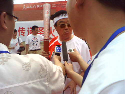 图文:泰州站圣火传递 火炬手徐镜人接受采访