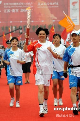 2008年5月27日,前国家女子排球运动员张洁云(右)点燃前国家男子排球