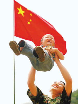 在青川参加抗震救灾的济南军区猛虎师战士把一个孩子高高举起。记者 曹 彤 摄