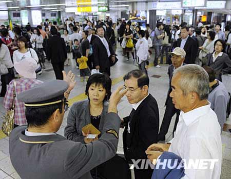 6月14日，在日本北部的仙台車站，工作人員通知旅客部分列車因地震暫時停運的消息。新華社/美聯
